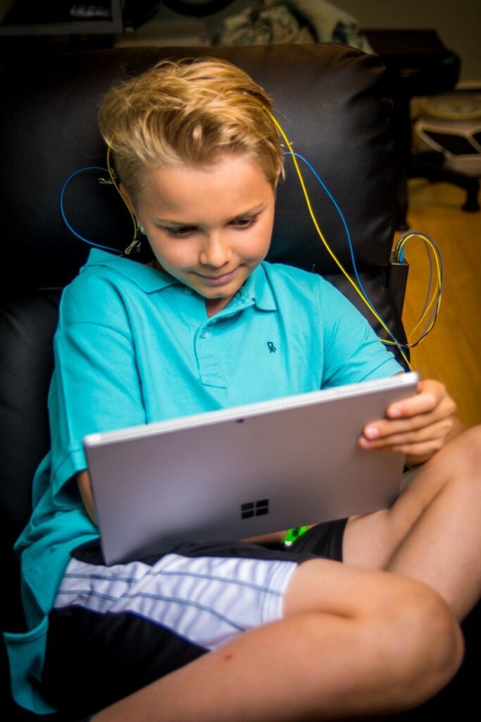 enfant en séance de neurofeedback avec capteurs, concentré devant une tablette chez capucine de villartay à asnières sur seine